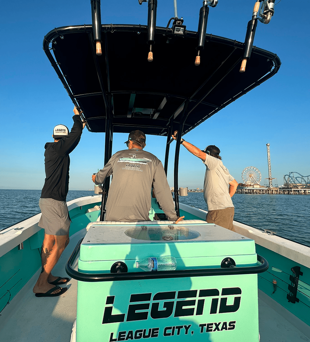Three men aboard Legend boat near pier